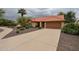 Inviting single-story home with desert landscaping, mature plantings and a large driveway at 9085 E Windrose Dr, Scottsdale, AZ 85260