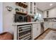 Kitchen featuring a wine fridge, granite counters and overhead stemware storage at 9085 E Windrose Dr, Scottsdale, AZ 85260