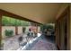 Relaxing covered patio and backyard featuring mature trees, and outdoor seating areas for entertaining guests at 9085 E Windrose Dr, Scottsdale, AZ 85260