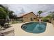 Backyard view of the refreshing pool and patio area with lounge chairs and shaded table offer a peaceful escape at 9085 E Windrose Dr, Scottsdale, AZ 85260