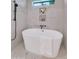Luxurious soaking tub with black fixtures, natural light, and marble-style tile surround at 9450 N 83Rd Pl, Scottsdale, AZ 85258