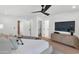 Comfortable bedroom with ceiling fan, hardwood floors, and a large TV at 9450 N 83Rd Pl, Scottsdale, AZ 85258