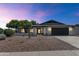 Stunning modern home with well-manicured landscaping, a dark garage door, and an inviting entrance at 9450 N 83Rd Pl, Scottsdale, AZ 85258