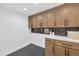 Well-lit laundry room showcasing wooden cabinetry, black backsplash, and ample counter space at 9450 N 83Rd Pl, Scottsdale, AZ 85258