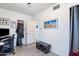 Bedroom with wood-look tile flooring, neutral walls, artwork, and access to another room at 9520 N Central Ave, Phoenix, AZ 85020