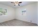 Bright bedroom features ceiling fan, natural light, wood-look tile floors, and white shuttered windows at 9520 N Central Ave, Phoenix, AZ 85020