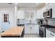 Modern kitchen with stainless steel appliances, granite countertops, white cabinets, and tile floors at 9520 N Central Ave, Phoenix, AZ 85020