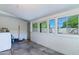 Laundry room with tiled floors, multiple windows, washer, and access to the exterior at 9520 N Central Ave, Phoenix, AZ 85020