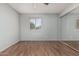 Bright bedroom with wood flooring, a window, and mirrored closet doors at 1010 E Buena Vista Dr, Tempe, AZ 85284