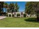 Desirable property featuring a circular driveway, desert landscaping, mature shade trees, and manicured green grass at 1010 E Buena Vista Dr, Tempe, AZ 85284