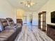 Comfortable living room with laminate flooring, featuring a recliner couch and convenient access to the bathroom at 10330 W Thunderbird Blvd # C206, Sun City, AZ 85351