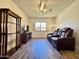 Cozy living room featuring laminate flooring, updated ceiling fan, and a sunny window view at 10330 W Thunderbird Blvd # C206, Sun City, AZ 85351