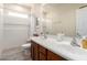 Bright bathroom featuring a double sink vanity with wood cabinets, tub with shower, and neutral tile at 10449 E Jacob Ave, Mesa, AZ 85209