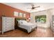 This bedroom features a green upholstered bed, two dressers, and a ceiling fan at 10449 E Jacob Ave, Mesa, AZ 85209
