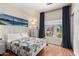 Bright bedroom featuring a comfortable bed, wood-style flooring, and natural light from a window at 10449 E Jacob Ave, Mesa, AZ 85209