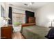 A serene bedroom with a wood-style floor, cozy bed, complemented by a ceiling fan, inviting comfort and relaxation at 10449 E Jacob Ave, Mesa, AZ 85209