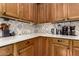 Close up on kitchen countertop featuring wooden cabinets with quartz counters and decorative tiled backsplash at 10449 E Jacob Ave, Mesa, AZ 85209
