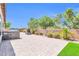 Paver patio featuring an outdoor grill, an outdoor fireplace, lush landscaping, and perimeter walls at 10664 E Ellis St, Mesa, AZ 85207