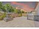 Spacious backyard featuring stone pavers, a built-in grill, an outdoor fireplace, and perimeter landscaping at 10664 E Ellis St, Mesa, AZ 85207