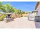 Spacious backyard featuring stone pavers, a built-in grill, an outdoor fireplace, and perimeter landscaping at 10664 E Ellis St, Mesa, AZ 85207