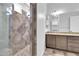Bathroom featuring tiled shower, stone countertop vanity, and decorative mirror at 10664 E Ellis St, Mesa, AZ 85207