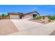 Expansive driveway leads to a well-maintained single-story home with a two-car and single-car garage at 10664 E Ellis St, Mesa, AZ 85207