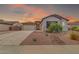 Lovely home featuring desert landscaping, rock accents, and a two-car garage under a vibrant sunset sky at 10664 E Ellis St, Mesa, AZ 85207