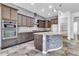 Modern kitchen with island, stainless steel appliances, dark wood cabinets, and mosaic-tiled bar area at 10664 E Ellis St, Mesa, AZ 85207