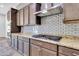 Modern kitchen with stainless steel appliances, dark wood cabinets, granite countertops, and subway tile backsplash at 10664 E Ellis St, Mesa, AZ 85207