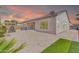 Paver patio with built-in grill, outdoor fireplace, and small patch of artificial turf at sunset at 10664 E Ellis St, Mesa, AZ 85207