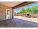 Covered patio featuring brick pavers, outdoor fireplace, and access door at 10664 E Ellis St, Mesa, AZ 85207