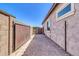 Wide view of side yard featuring a well-maintained brick walkway with secured gates on either end at 10664 E Ellis St, Mesa, AZ 85207