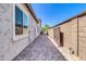 Long view of side yard featuring a well-maintained brick walkway with secured gates on either end at 10664 E Ellis St, Mesa, AZ 85207
