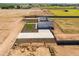 Aerial view showcases a modern home featuring a long driveway, green lawn squares, set against a rural backdrop at 11564 E Windsor Way, Florence, AZ 85132