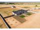 Aerial view of a modern home with a dark roof and green lawn squares in a desert landscape with mountain views at 11564 E Windsor Way, Florence, AZ 85132