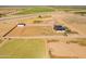 Aerial shot showing new farmhouse, barn, and building foundation with agricultural fields in distance at 11564 E Windsor Way, Florence, AZ 85132