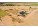 Aerial view of expansive property with modern home, large fenced yard, and storage shed, farmland in distance at 11564 E Windsor Way, Florence, AZ 85132