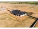 Aerial view of a modern home with dark roof, white exterior, and large desert lot with a block fence at 11564 E Windsor Way, Florence, AZ 85132