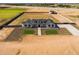 Aerial view of modern farmhouse with extensive landscaping, on fenced lot with detached metal barn at 11564 E Windsor Way, Florence, AZ 85132