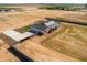 Aerial view of a modern home with a dark roof, concrete driveway, and surrounded by natural desert landscape at 11564 E Windsor Way, Florence, AZ 85132
