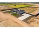 An aerial view of a modern single-Gathering home with a long driveway, pristine landscaping, and surrounded by farmland at 11564 E Windsor Way, Florence, AZ 85132