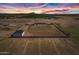 Aerial shot of modern home on fenced lot, complete with barn, desert surroundings and beautiful sunset at 11564 E Windsor Way, Florence, AZ 85132