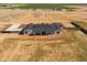 Aerial view of a modern, white, single-story house with a dark roof in a rural desert landscape at 11564 E Windsor Way, Florence, AZ 85132