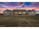 Exterior of home at sunset with a covered patio and a spacious backyard at 11564 E Windsor Way, Florence, AZ 85132