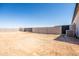 Spacious backyard enclosed by a solid block wall and an black gate, providing privacy, security, and potential at 11564 E Windsor Way, Florence, AZ 85132