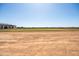 Large backyard with dirt and grass area with a newly built home with black roof at 11564 E Windsor Way, Florence, AZ 85132