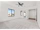 Airy bedroom featuring neutral carpet, a modern ceiling fan, and a view to the backyard at 11564 E Windsor Way, Florence, AZ 85132