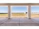 Covered patio overlooking a large fenced backyard with a distant barn or storage shed at 11564 E Windsor Way, Florence, AZ 85132