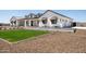 Well manicured lawn and drought tolerant landscaping surrounding the white farmhouse at 11564 E Windsor Way, Florence, AZ 85132