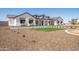 New construction farmhouse-style home with pristine white exterior and professional desert landscaping at 11564 E Windsor Way, Florence, AZ 85132